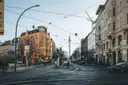 A Berlin street of old apartment buildings, with tram wires and the TV Tower behind
