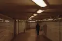 A bright, empty underground walkway with a long row of lights