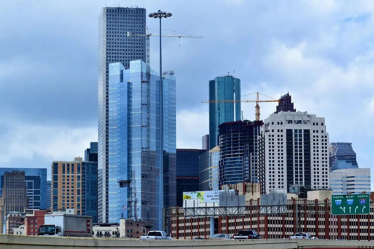 Glass and stone towers of downtown Houston under a cloudy sky