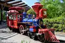 The red and blue engine of the little Hermann Park train at its station