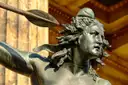 A bronze sculpture of a woman with flowing hair, seen up close