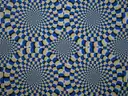 An optical illusion of blue, black and cream circles that seem to turn