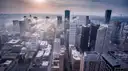 Downtown Houston's towers seen from above, with low clouds between them