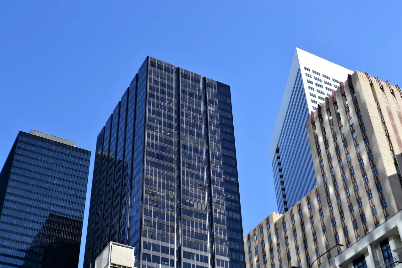 Downtown Houston office towers seen from street level against a blue sky