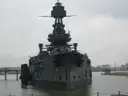 Battleship Texas at its former berth under a gray sky