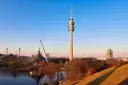 The Olympic Tower and the tent roof of the Olympic Park in Munich above a lake