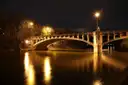 The Maximilian Bridge over the Isar river in Munich at night, lit by street lamps