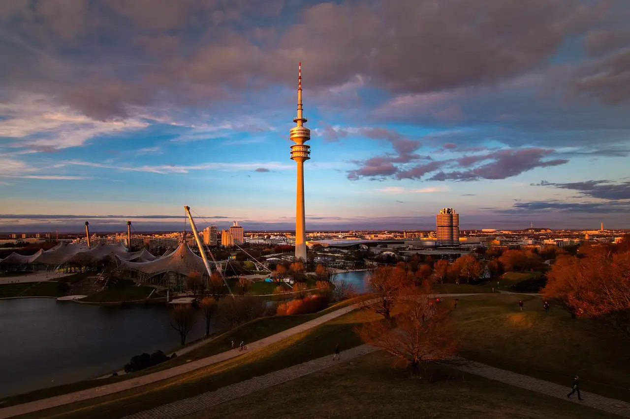 The Olympic Tower in Munich at dusk, seen from the Olympic Park hill with the tent roofs below