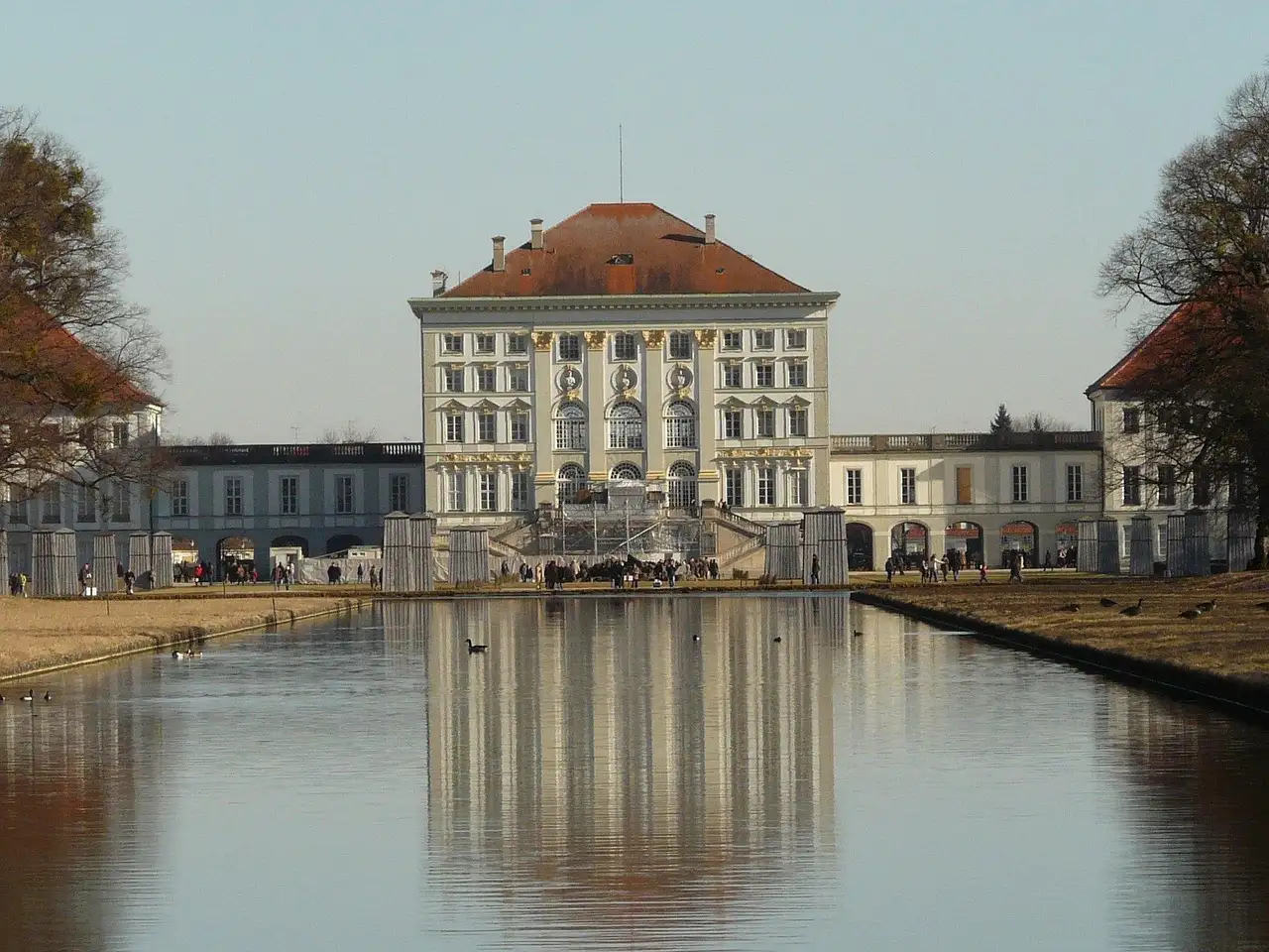 The front of Nymphenburg Palace reflected in the still canal