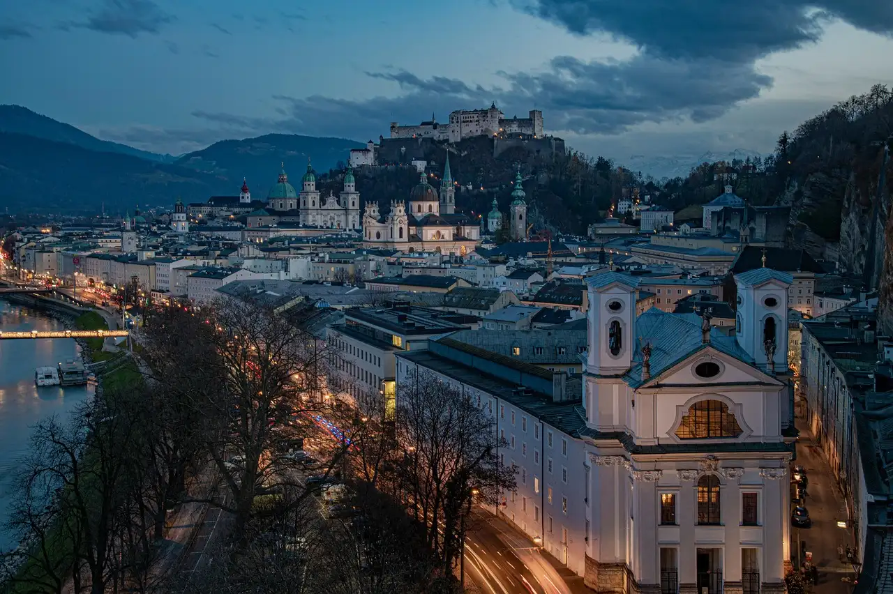 Salzburg at dusk, with the river, church towers and the fortress on the hill