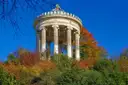 The round Monopteros temple among autumn trees in the English Garden in Munich