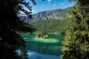 Lake Eibsee with clear green water and small wooded islands, framed by fir trees