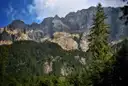 The rock walls of the Zugspitze massif above dark green forest