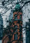 The red-brick Gooderham Building in old Toronto seen through bare tree branches