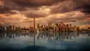 The CN Tower and the downtown Toronto skyline across the water under heavy evening clouds, mirrored in the lake
