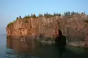 A limestone headland with a cave arch over still water on Georgian Bay