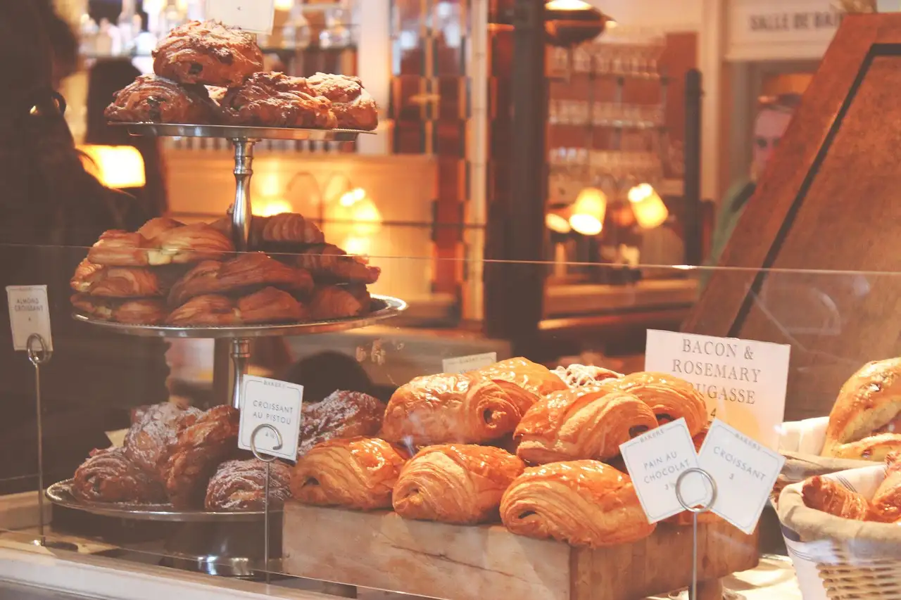 Croissants and chocolate pastries in a bakery window in warm light