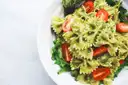 A plate of pesto pasta with cherry tomatoes