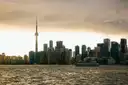 A cruise boat on the harbour in front of the CN Tower and downtown Toronto at sunset