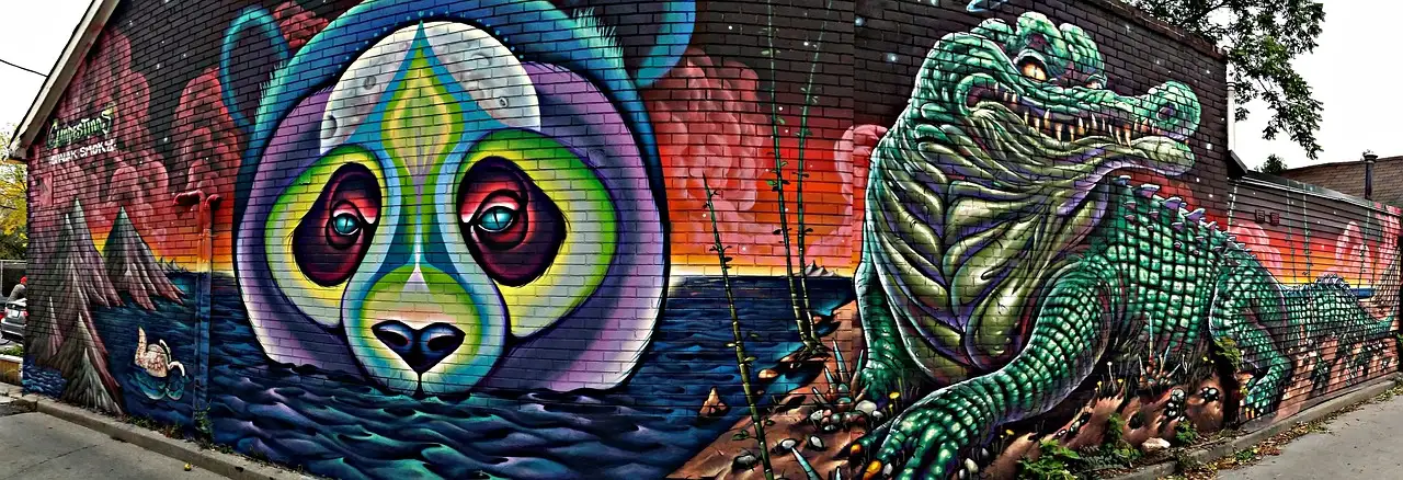 A large street-art mural of a panda face and an alligator on a Toronto wall
