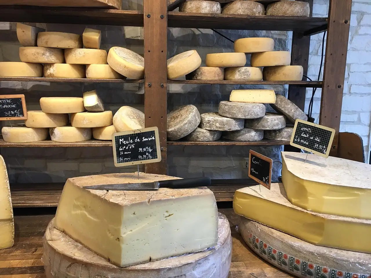 Wheels of cheese on wooden shelves in a cheese shop