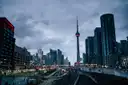 Railway tracks leading into downtown Toronto at dusk, with the CN Tower ahead