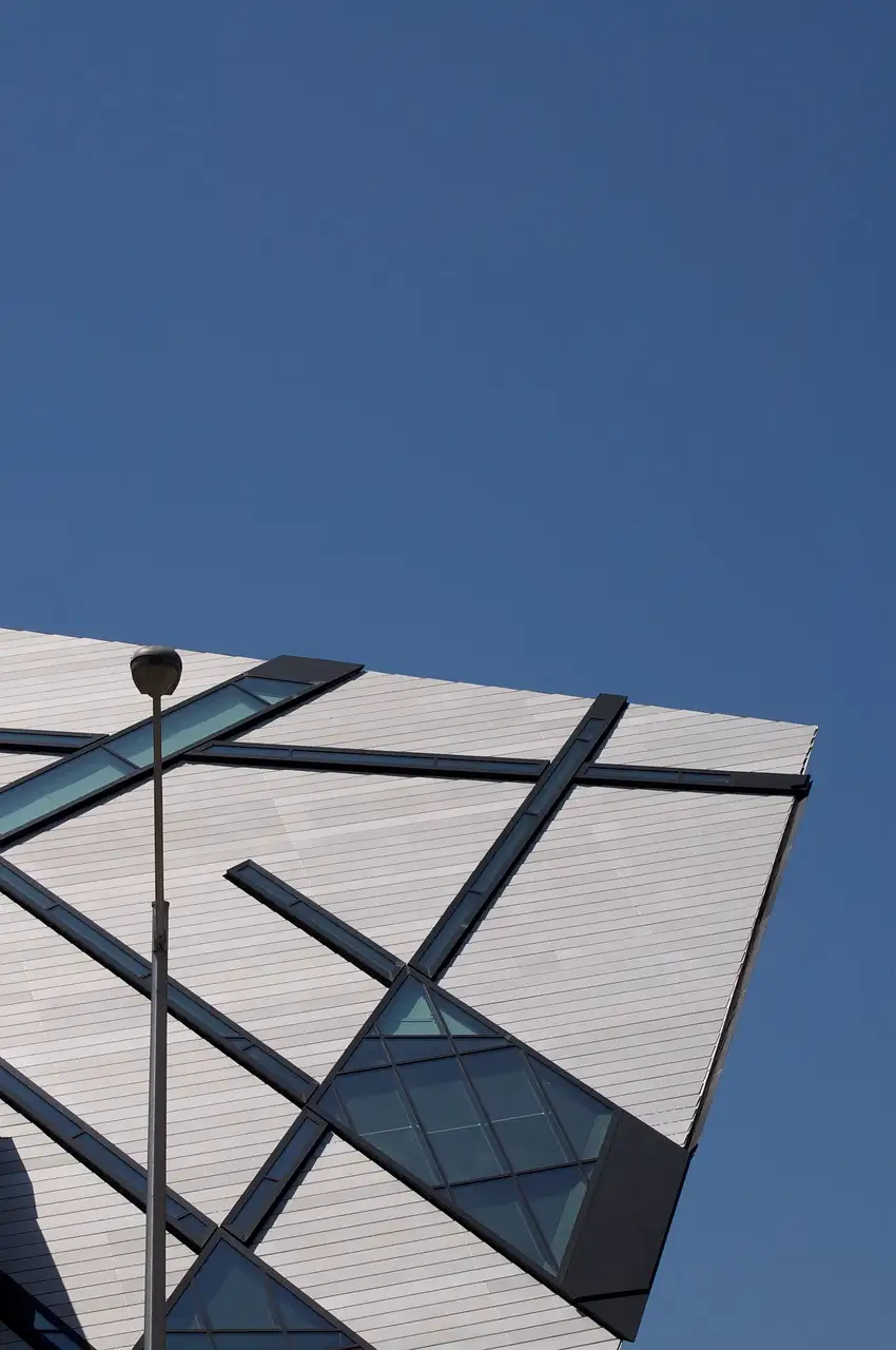 A corner of the Royal Ontario Museum's angular crystal-shaped wing, with metal panels and glass strips against a blue sky