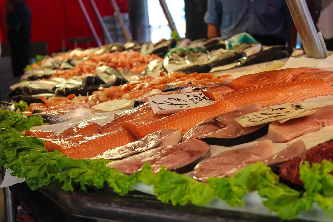 Fresh fish and salmon fillets on ice at a market counter