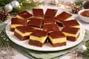 A plate of Nanaimo bars with a chocolate top and custard layer