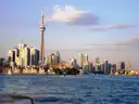 The CN Tower and downtown skyline across the harbour, seen from a boat in evening light