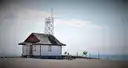 A white lifeguard hut on a sandy Toronto beach by the lake