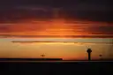 The Toronto Pearson control tower in silhouette at sunset